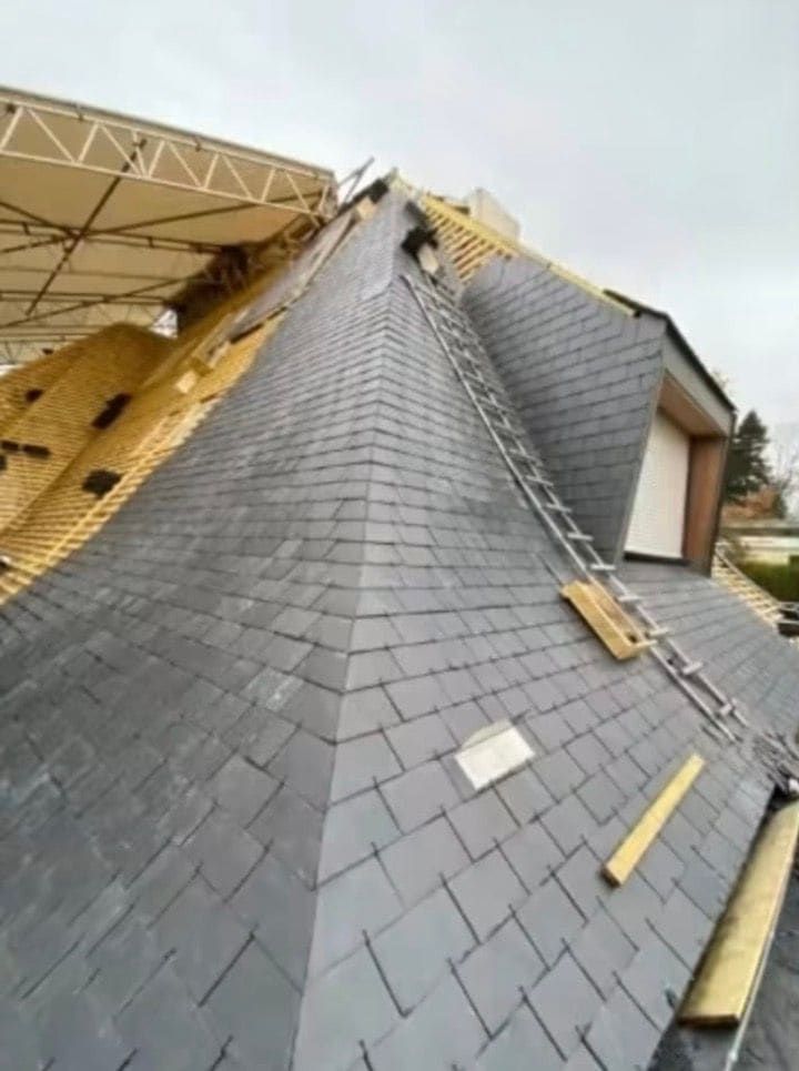 Arêtier d'une toiture en ardoise en cours de couverture