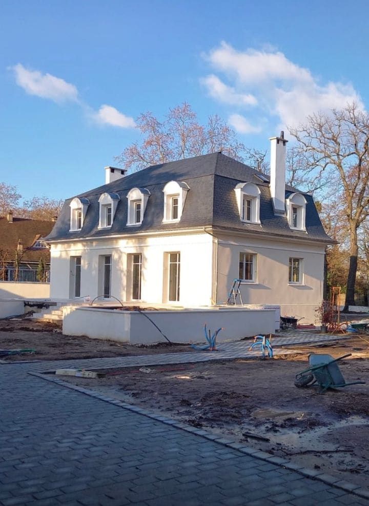 Grande maison dont la toiture vient d'être achevée, vue depuis le toit voisin