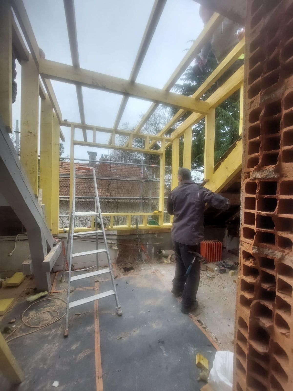 Ossature bois d'une extension montée contre un mur existant